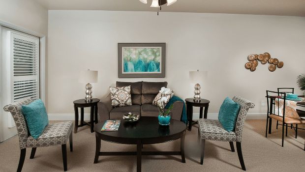 A cozy living room with a sofa, armchairs, and coordinating decor in teal and neutral tones.