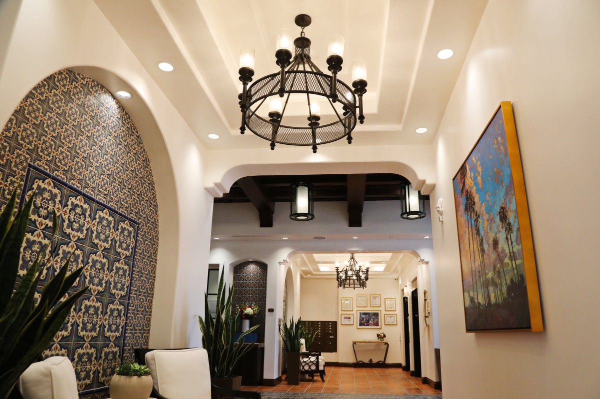A beautifully designed hallway featuring a large chandelier and modern decor.