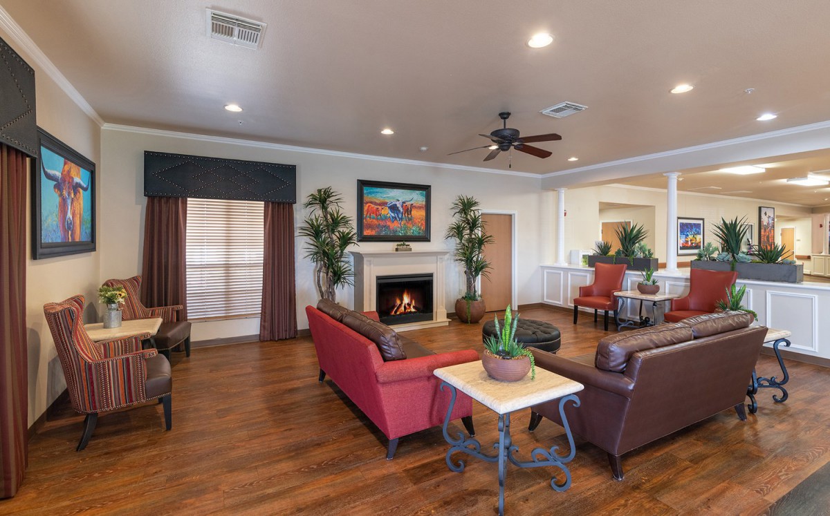 A cozy living room with a sofa, fireplace, and wooden flooring.