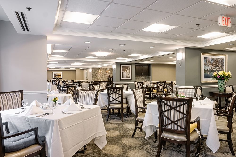 An elegant dining room with set tables and chairs, ready for guests.