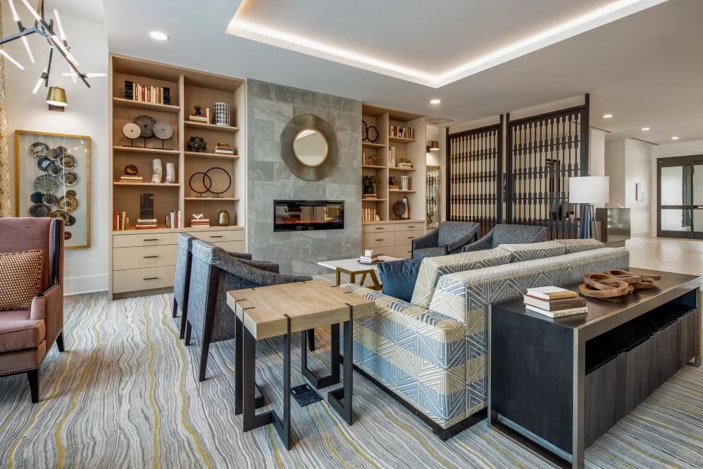 A modern living room with stylish decor, featuring a fireplace and built-in bookshelves.
