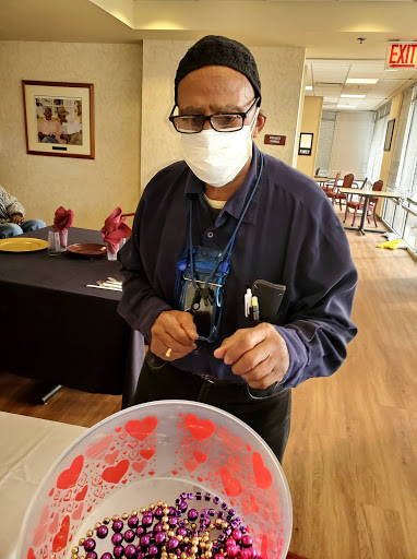 A person wearing a mask is engaged in an activity with a bowl of red paint indoors.