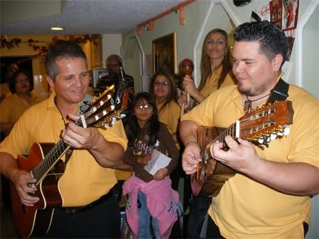 A group of musicians performing with guitars indoors.