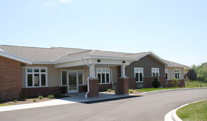 A modern building with a covered entrance and large windows.