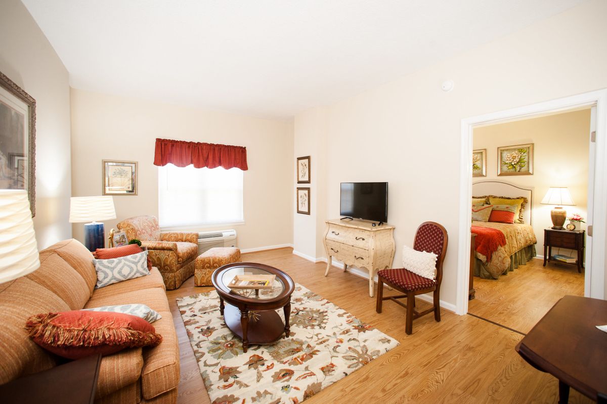 A cozy living room with comfortable seating, a TV, and a decorative rug.