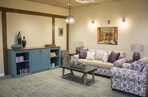 A cozy living room featuring floral patterned furniture, a rustic coffee table, and tasteful decor.