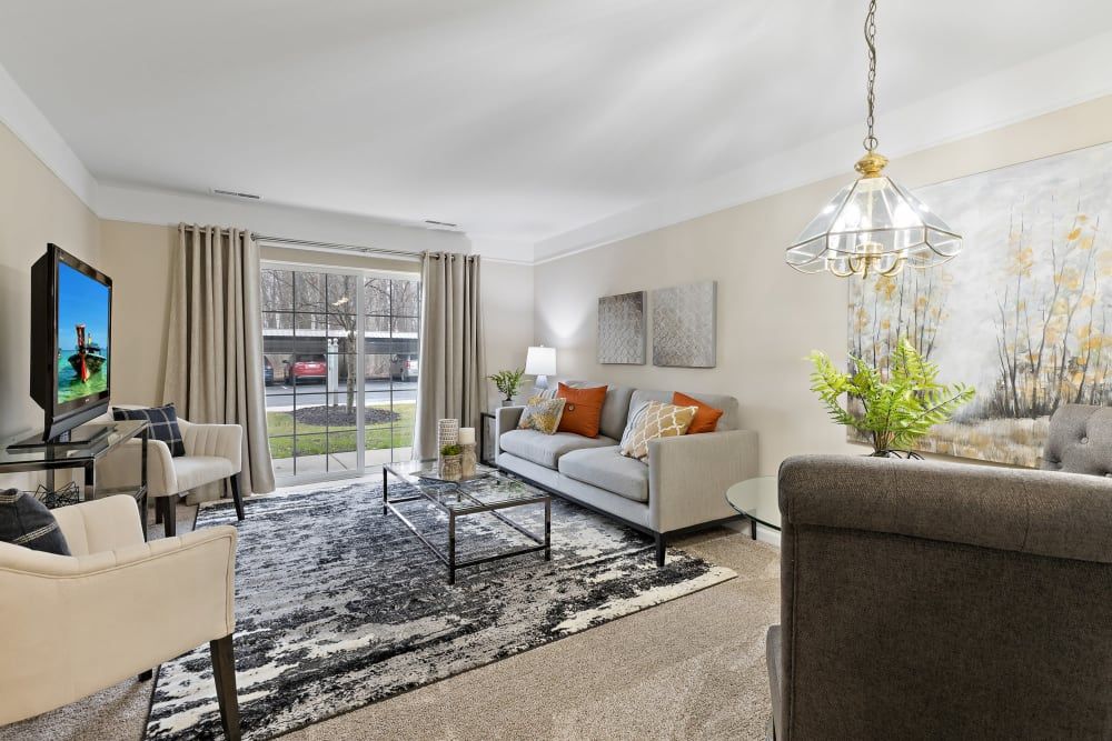 A modern living room with a comfortable sofa, stylish coffee table, and large glass doors leading outside.