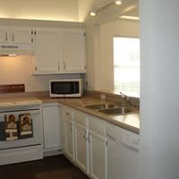 A cozy kitchen with white cabinets, a microwave, and a sink.
