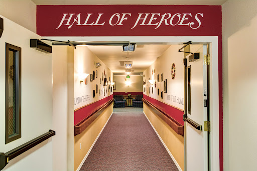 The entrance to the Hall of Heroes, showcasing a decorated hallway filled with art and recognition.