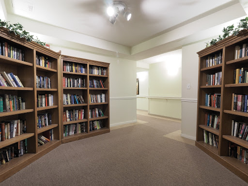 A cozy library corner with wooden bookshelves filled with various books.