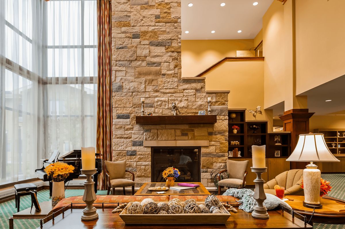 A modern living room with a stone fireplace and cozy decor.