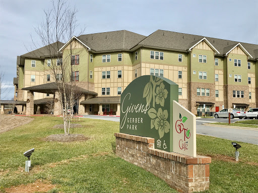 A view of a residential building with a welcoming sign in front.