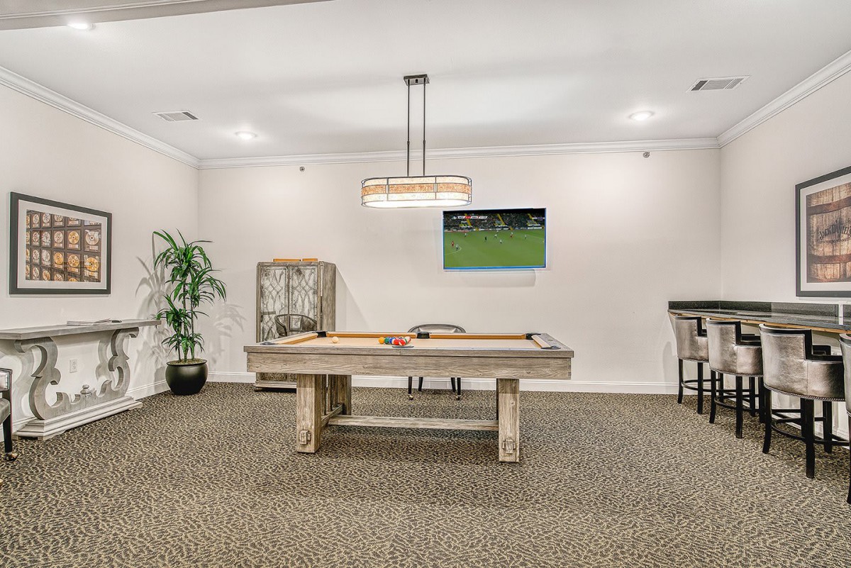 A well-designed billiard room featuring a pool table, television, and stylish decor.