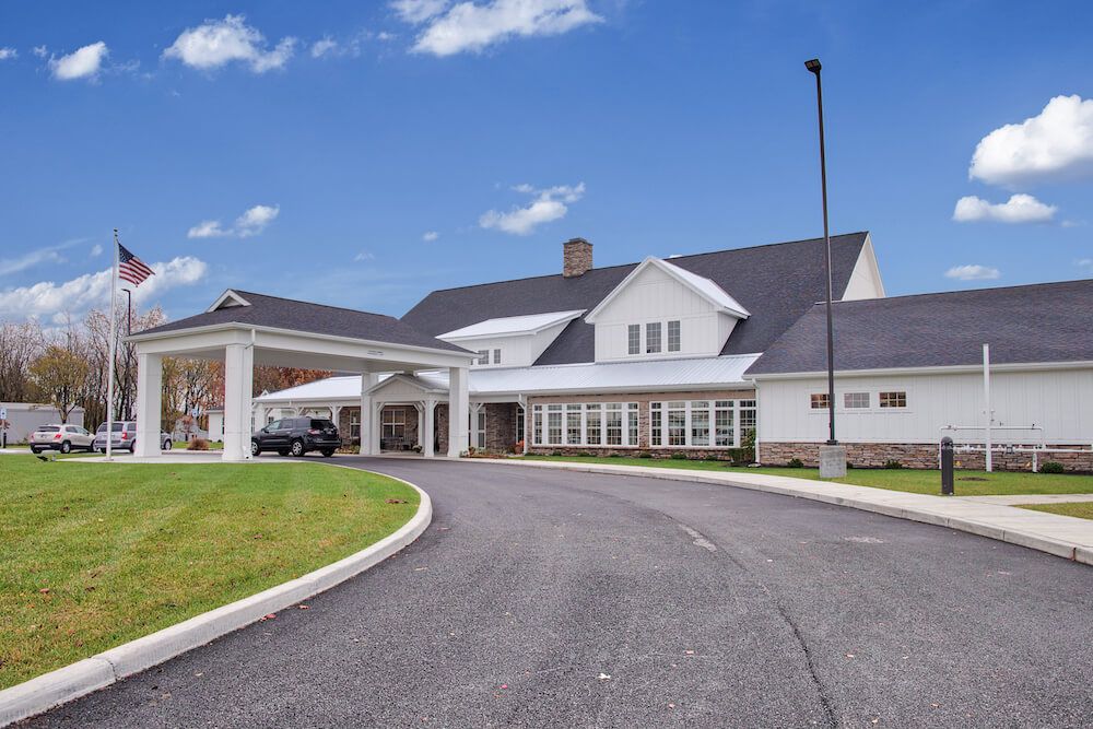 A large residential-style building with a driveway and clear blue sky.