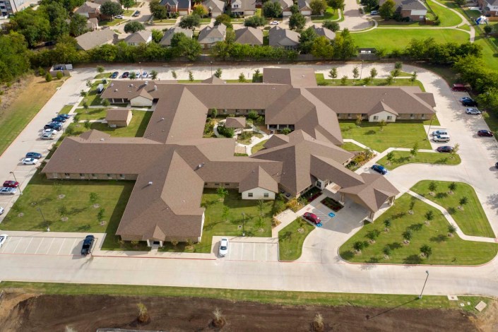 Aerial view of a large residential complex with landscaped grounds and parking areas.