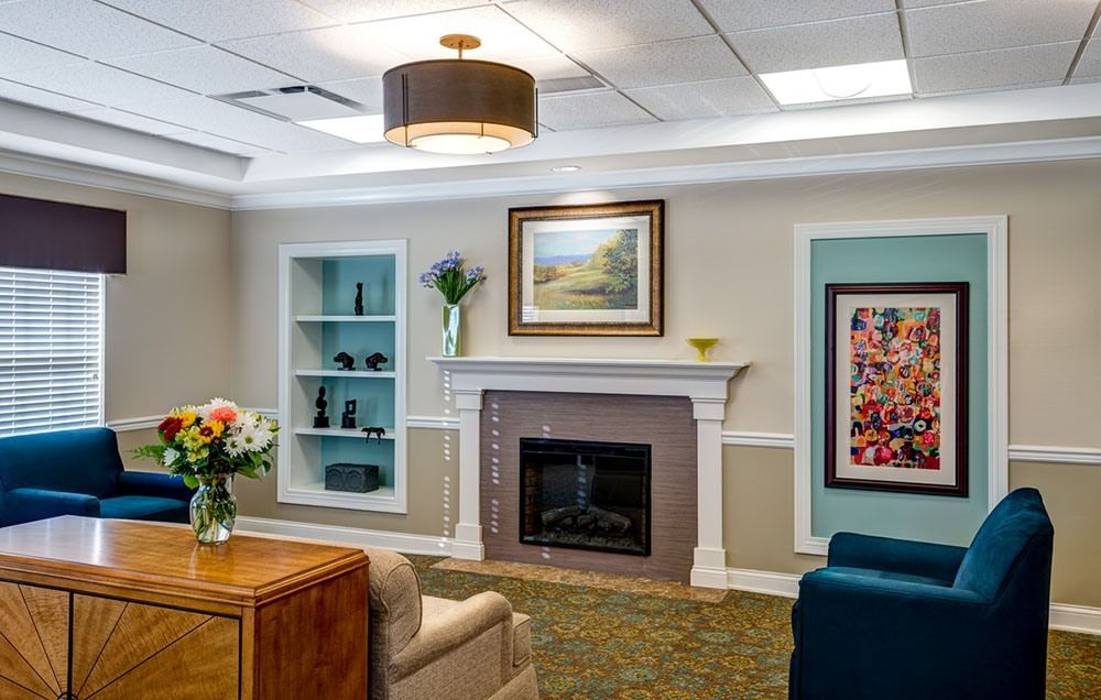 A cozy living room with a fireplace, comfortable seating, and decorative artwork.