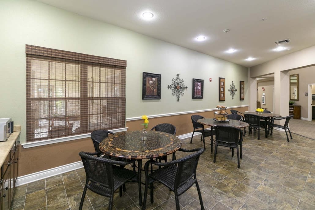 A modern dining area with tables and chairs, decorated with artwork and warm lighting.