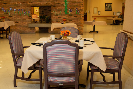 A cozy dining setup featuring a table with elegant chairs and a floral centerpiece.