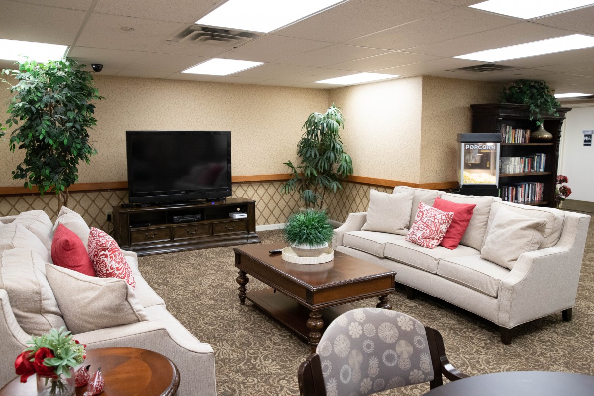 A cozy living room with comfortable sofas, a large television, and charming decor.