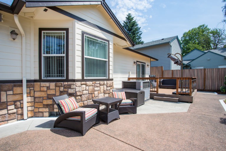 A cozy backyard patio featuring comfortable seating and a deck.