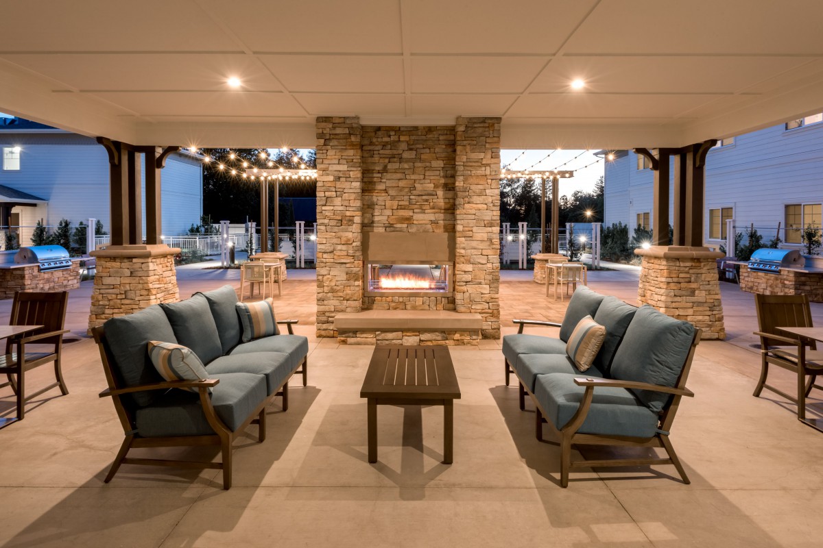 Cozy outdoor patio with a fireplace and comfortable seating.