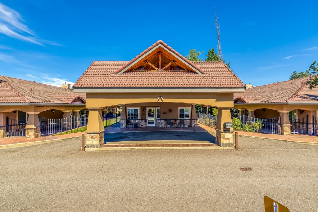 A welcoming entrance of a building featuring an expansive awning and a sloped roof.