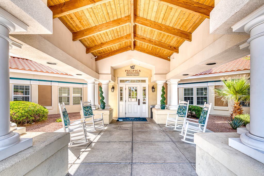 A welcoming entrance with rocking chairs under a covered walkway.