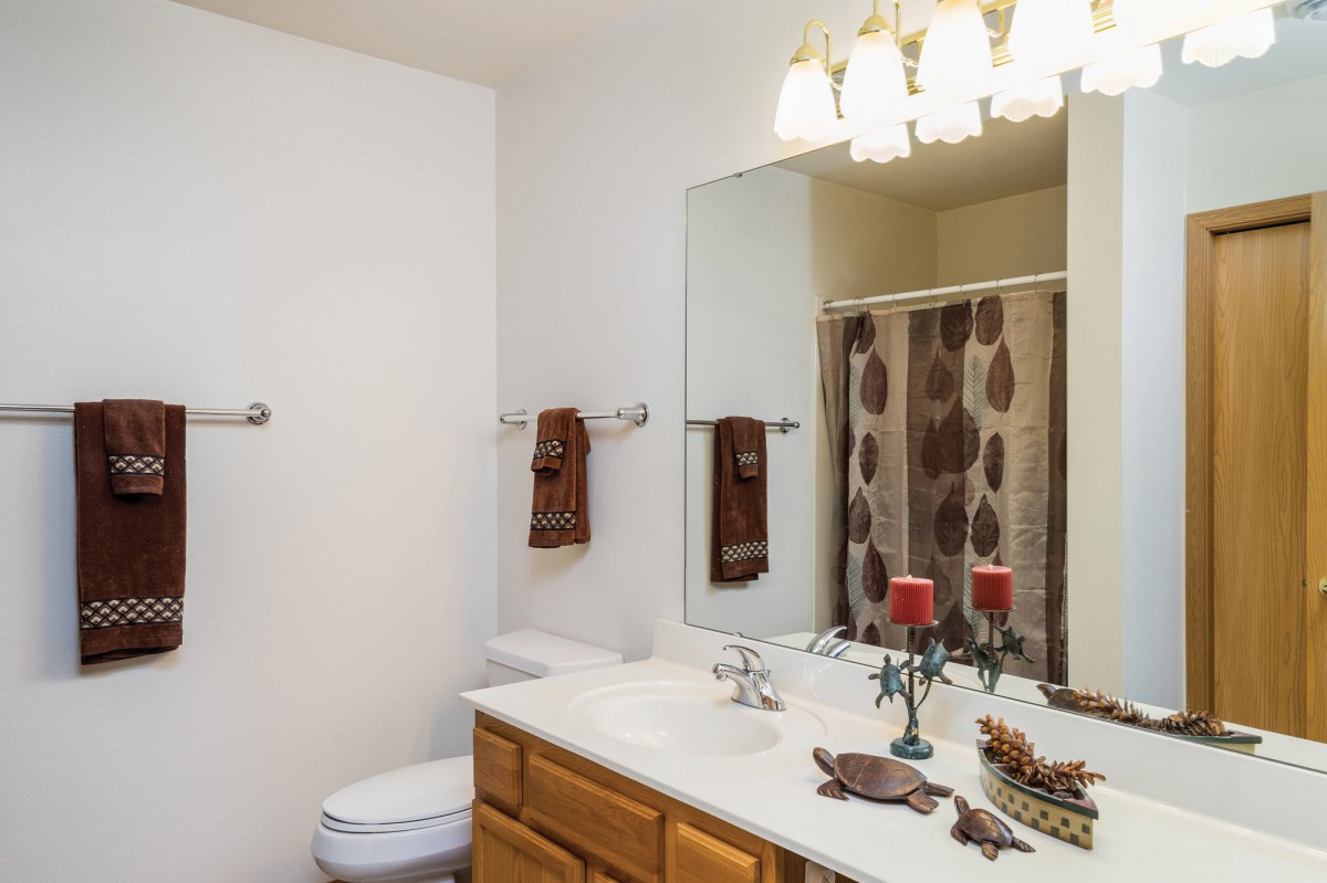 A well-decorated bathroom with a large mirror and elegant lighting.