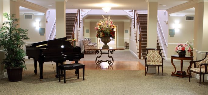 A welcoming lobby with a grand piano and elegant floral decoration.