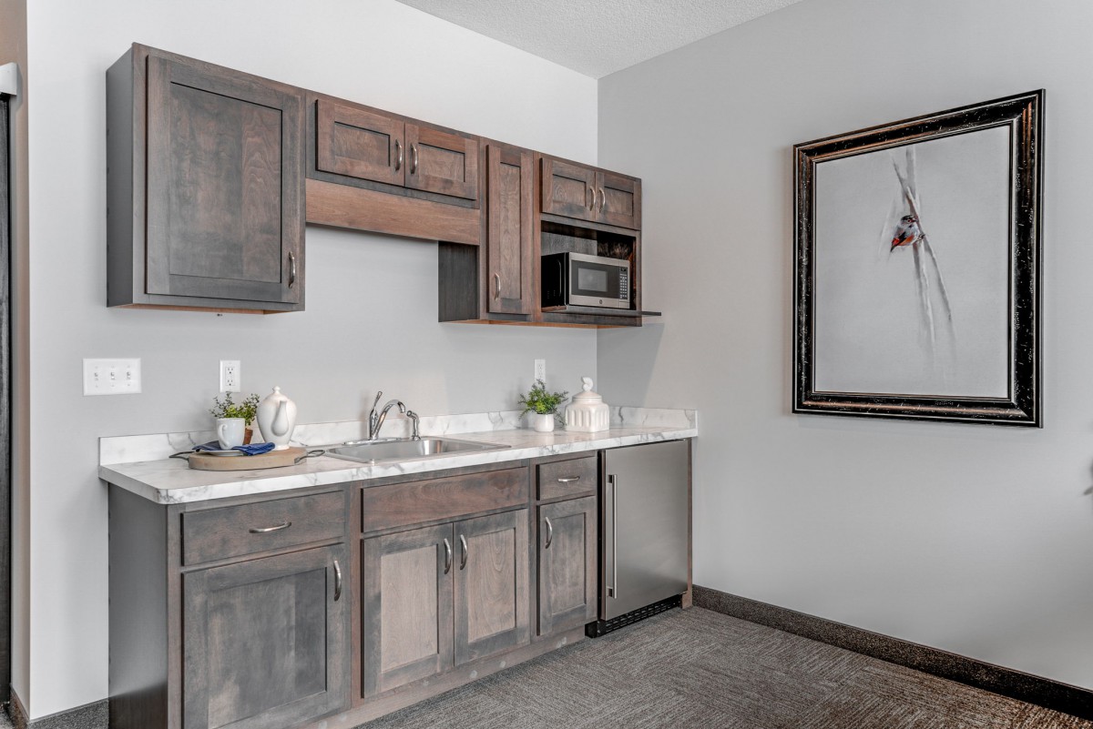 A modern kitchen with wooden cabinets and a white countertop.