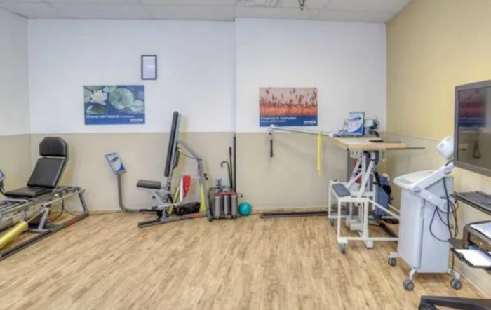 A gym interior with various fitness equipment and workout gear.