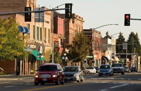 A bustling downtown street lined with historic buildings and busy with traffic.