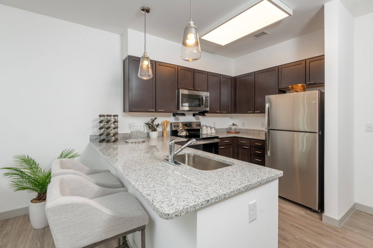 A modern kitchen with stainless steel appliances and granite countertops.