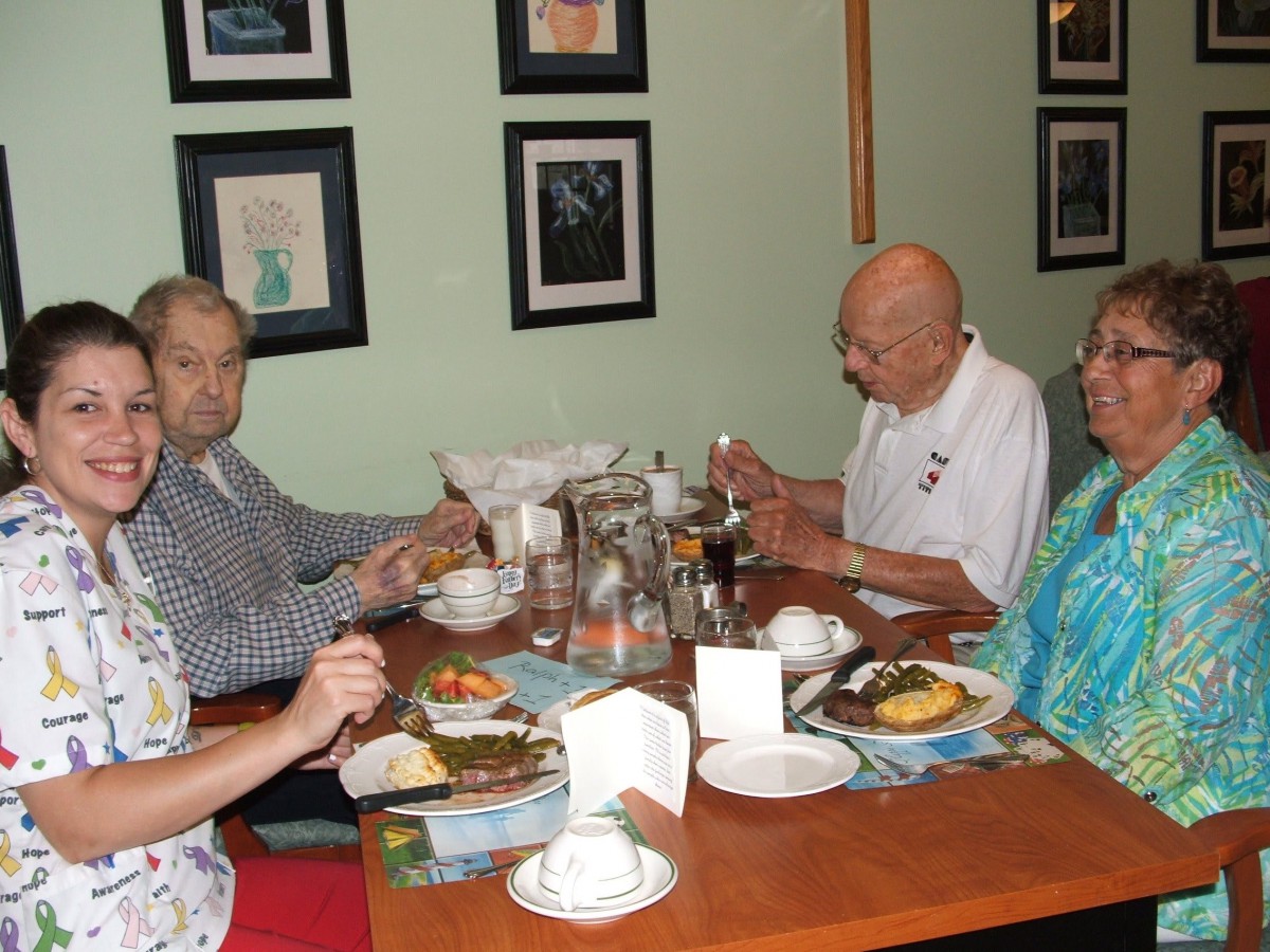 A group of four people enjoying a meal together at a restaurant table.