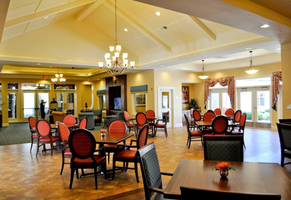 A well-lit dining room with elegant seating arrangements and a chandelier.