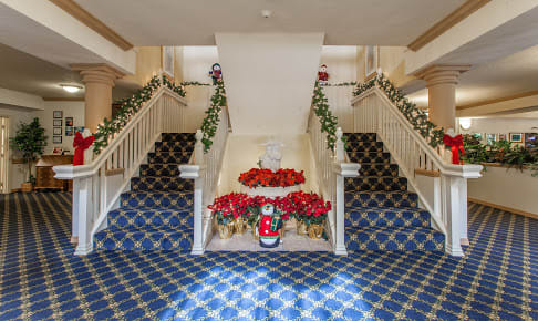 A beautifully decorated staircase with holiday-themed garlands and flowers.