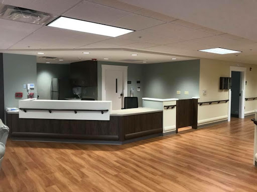 A modern reception area with a wooden floor and sleek furniture.