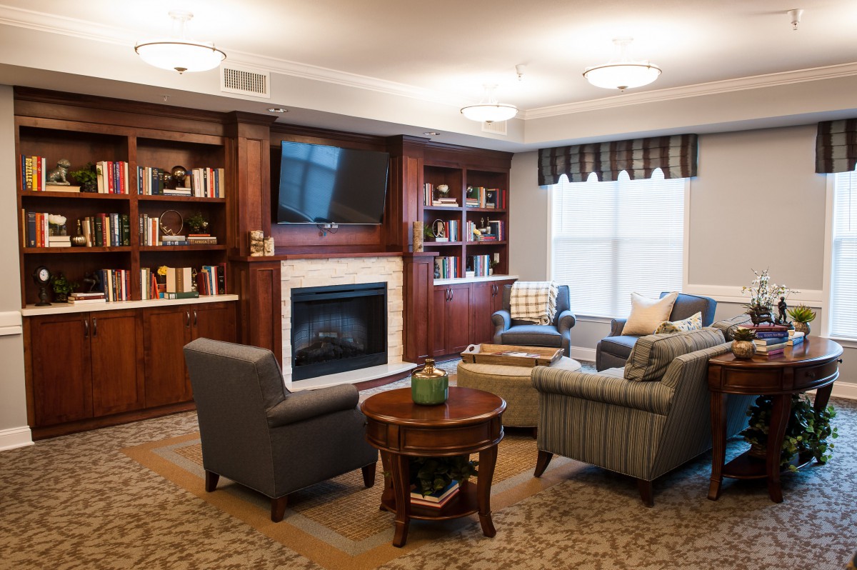A cozy living room with a fireplace, bookshelves, and comfortable seating.