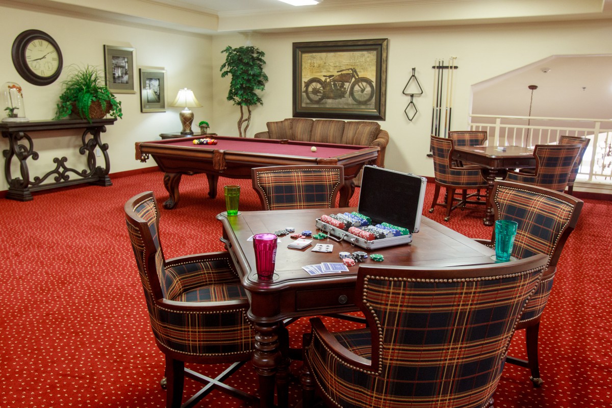 A cozy game room featuring a pool table, board games, and comfortable seating for relaxation and entertainment.