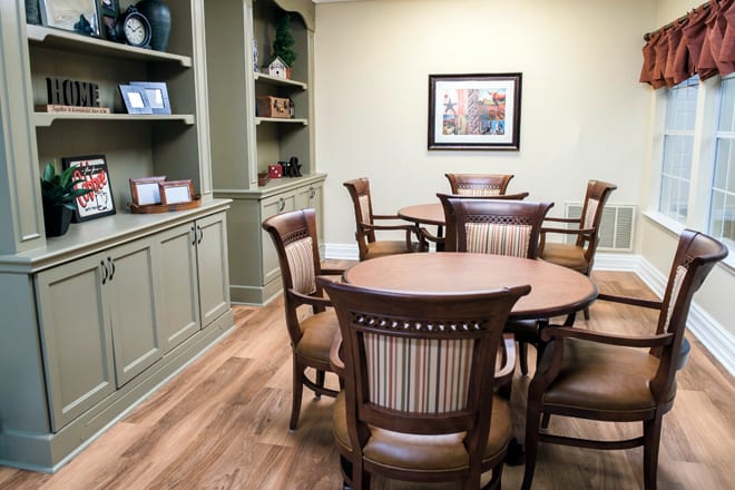 A cozy dining area with wooden tables and chairs, featuring built-in shelves for decor.