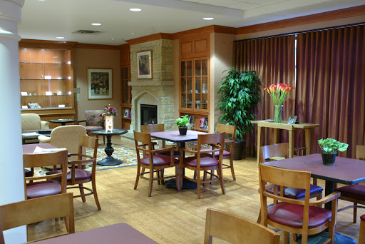 A cozy lounge area featuring wooden furniture, plants, and a fireplace, perfect for relaxation.