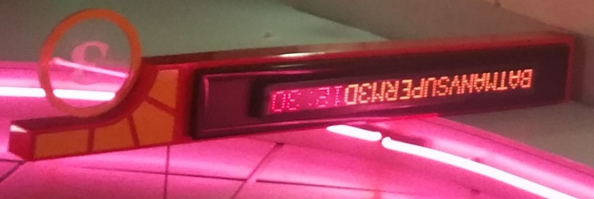 An illuminated emergency exit sign displaying 'EXIT' in red LED lights.