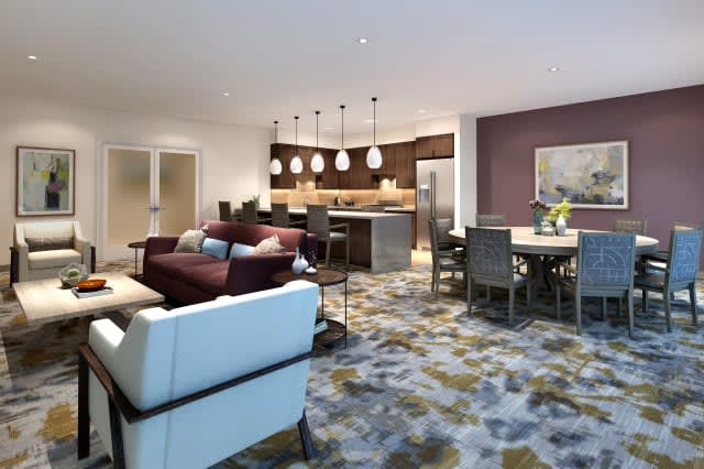A modern open-concept living area featuring a cozy living room, kitchen, and dining space.