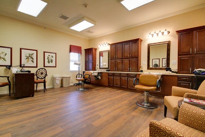 A cozy salon interior with chairs, mirrors, and wooden flooring.