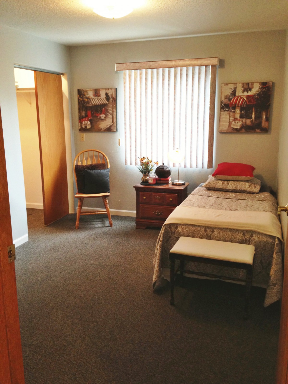A simple and tidy bedroom with a single bed, chair, and decorative elements.
