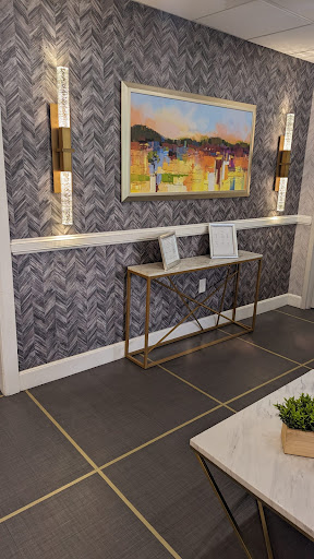 A stylish modern interior featuring a console table, artistic wall decor, and elegant lighting.