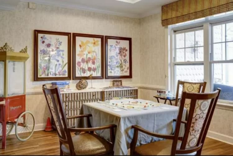 A cozy dining room with floral artwork and a table set for four.