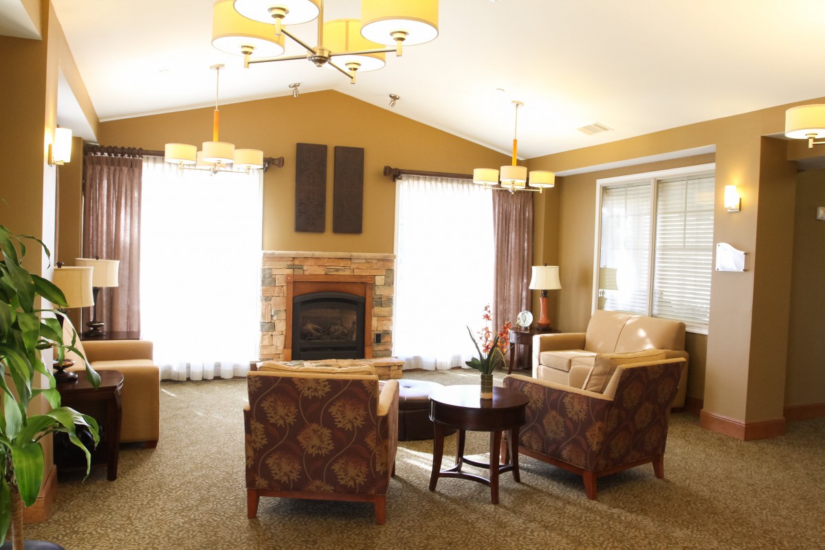 A cozy living room setting featuring a fireplace, comfortable seating, and warm lighting.