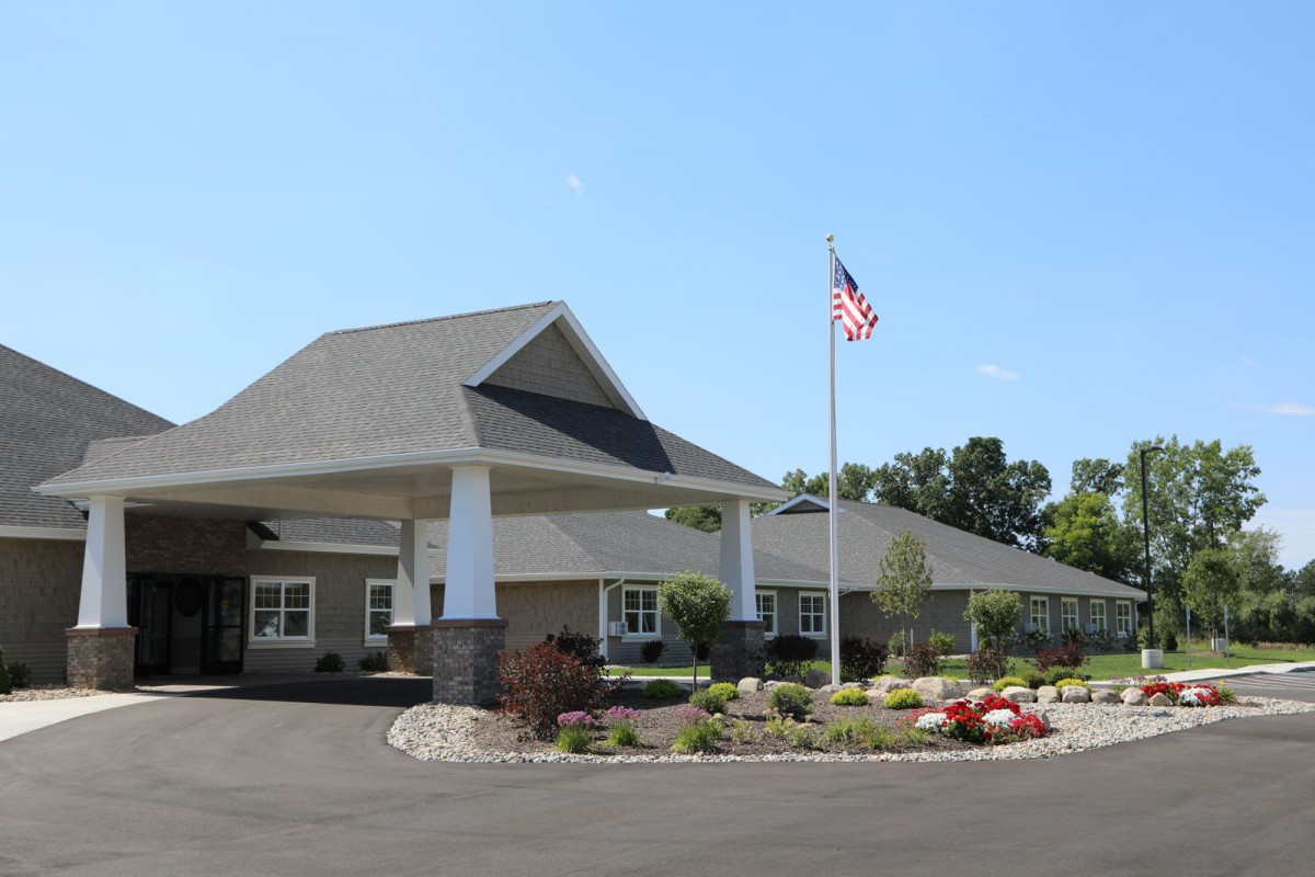 A well-maintained building with landscaped surroundings and an American flag in front.