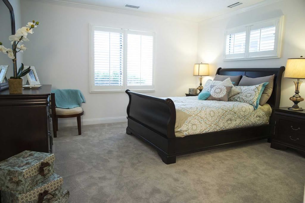 A cozy bedroom with a stylish bed and soft lighting.